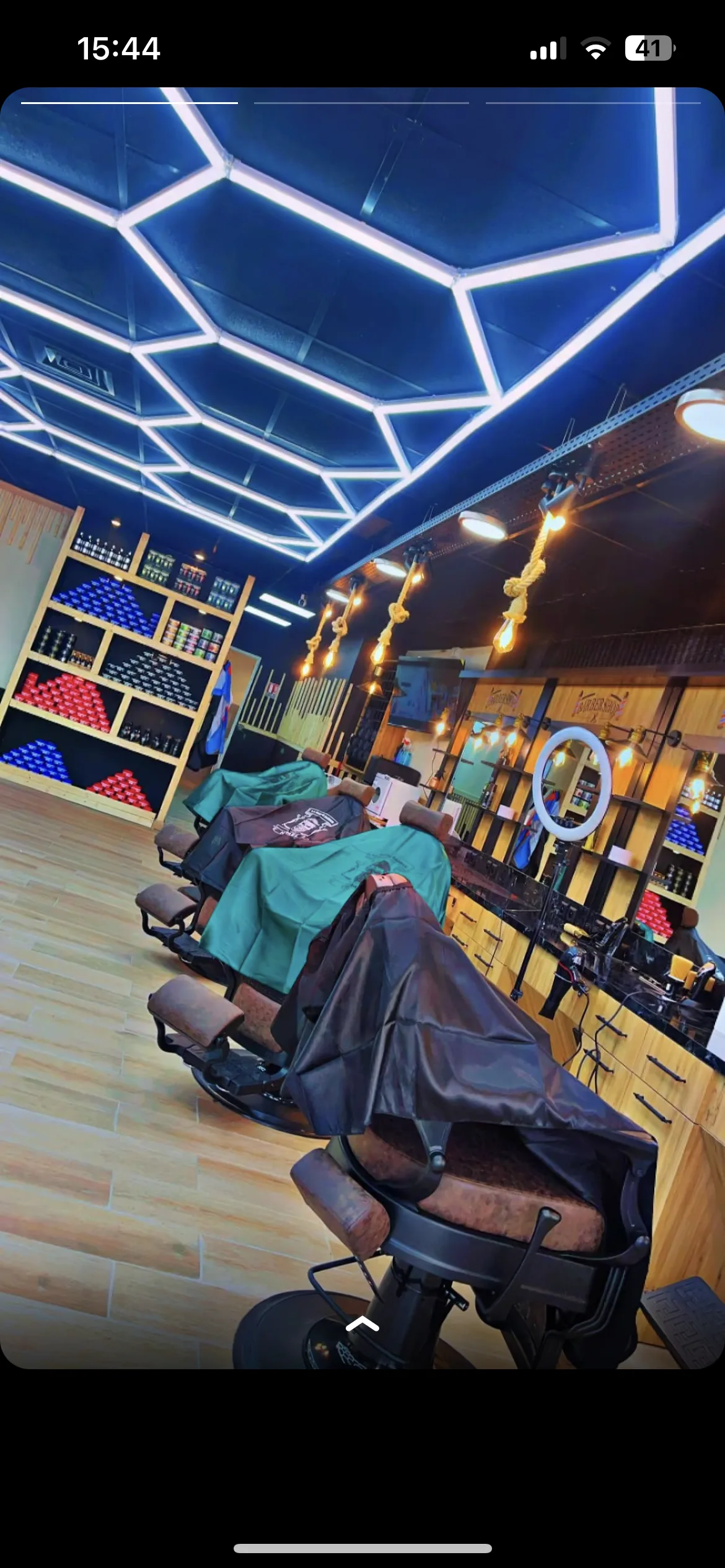 Détail du plafond hexagonal de La Pause Barber : les tubes lumineux dessinent un nid d'abeilles sur le plafond sombre